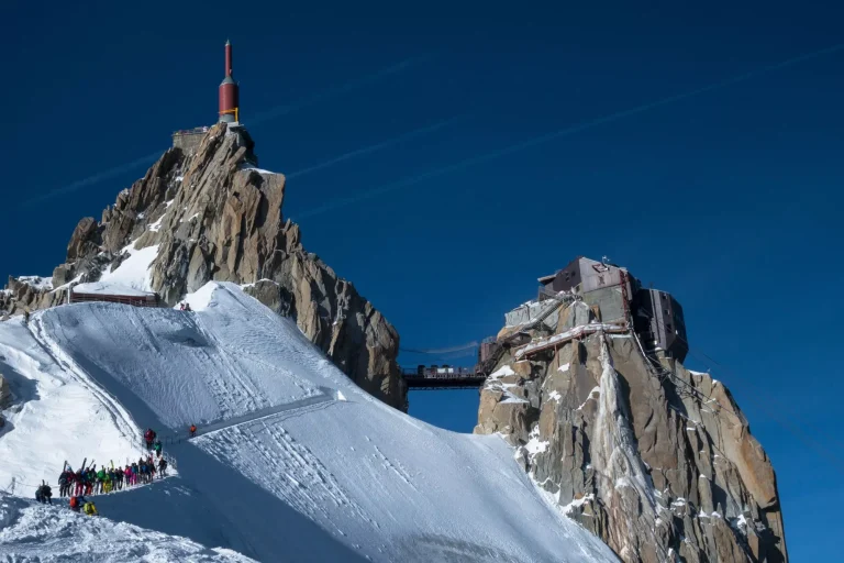 Eine Reihe von Skifahrern auf dem Grat der Aiguille du Midi im Winter