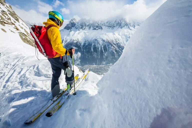 Skifahrer auf dem Gipfel stehend, Schnee, sonniger Tag
